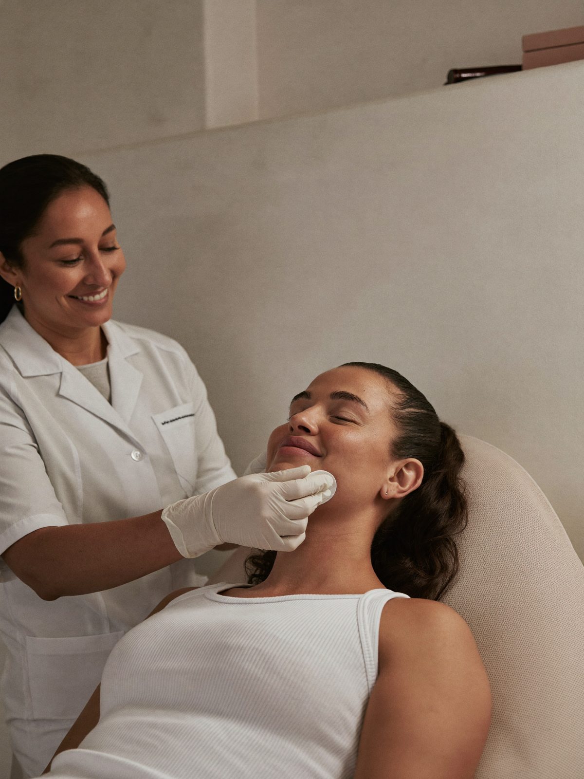 Médica evaluando la piel del rostro de una paciente